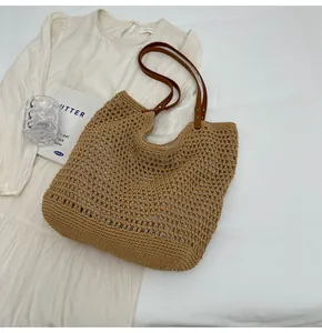 Detail of handmade woven cotton rope tote bag with brown leather handles and mesh pattern