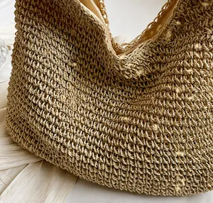Detail shot of khaki woven straw tote bag featuring thick paper rope texture and inner lining