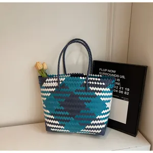 Détail du cabas tressé tricolore avec motifs en losanges bleus blancs et gris