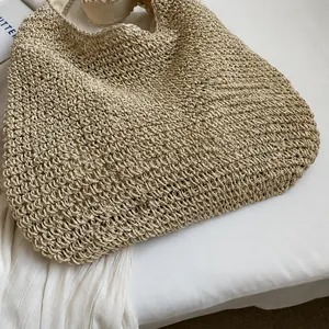 Close-up of beige woven tote bag showing detailed straw texture and soft fabric