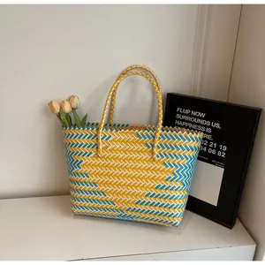 Détail du sac fourre-tout tissé à la main avec motif en chevrons bleu et jaune et anses