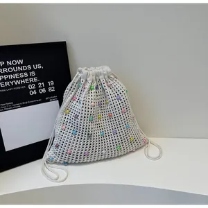 Close-up detail of cream knit tote bag featuring colorful pastel bead decorations