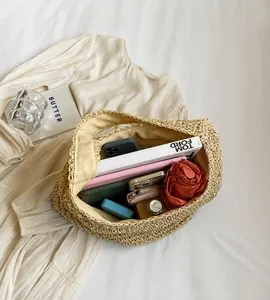 Macro view of spacious interior in a woven straw hobo bag with daily essentials