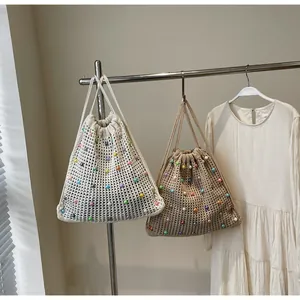 Detail of hand-woven drawstring bags with colorful beads in white and khaki tones