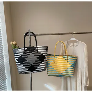 Détails de sacs cabas tissés à la main avec motifs géométriques sur support en acier