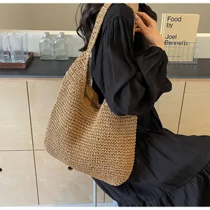 Detail of hand-woven straw shoulder bag showing fine texture and large hobo capacity