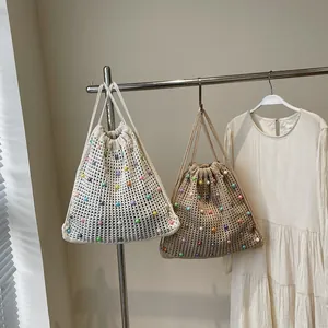 Handmade woven drawstring bucket bags in white and beige with colorful bead accents