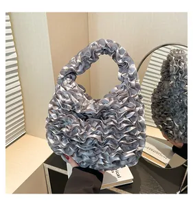 Detail of silver grey pleated satin handbag featuring elegant ruffle craftsmanship