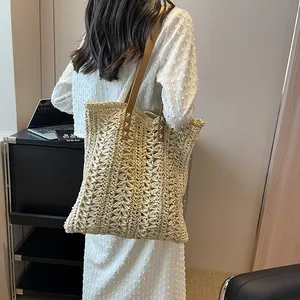 Minimalist large woven straw tote bag with brown leather straps for summer beach holidays