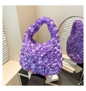 Detailed view of purple satin pleated handbag with ruffles and bubble texture