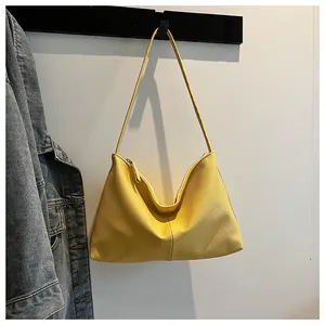 Close-up of bright yellow shoulder bag with premium litchi texture and top zipper