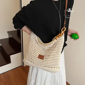 Women straw woven tote bag with wooden bead strap and leather patch for summer beach vacations