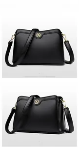 Close-up of black lychee grain leather handbag with gold metal logo and strap hardware