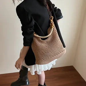 Bohemian woven straw shoulder bag with wooden beads decoration for summer beach vacations