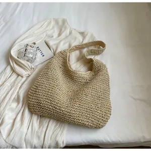 Detail of hand-woven straw tote bag texture and inner fabric lining on a white dress