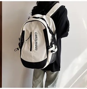 Détail d'un grand sac à dos scolaire noir et blanc avec poches filet et logo CAROLMANTI