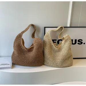 Detail of woven straw tote bags in brown and beige colors with natural fiber texture