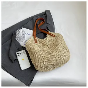 Détail du sac cabas en paille tissée main avec lanières en cuir marron et doublure