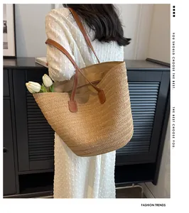 Close-up of woven straw tote bag with brown leather handles and interior lining detail