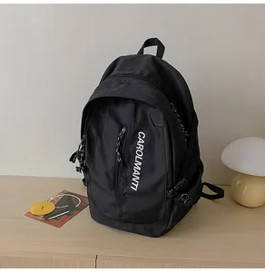 Gros plan d'un sac à dos noir imperméable avec boucles latérales et logo vertical blanc