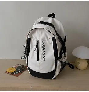 Vue détaillée de dessus d'un sac à dos minimaliste noir et blanc posé sur un bureau en bois