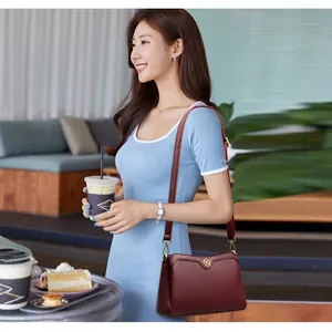 Chic burgundy faux leather shoulder bag with gold logo for women in lifestyle setting