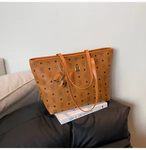 Details der braunen Vintage-Einkaufstasche mit Bärenprint und Logo auf einem Buch