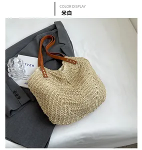 Détail du sac cabas beige en paille tissée main avec bandoulière en cuir marron