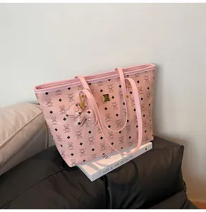 Nahaufnahme der rosa Totebag mit Bärenprint, Goldlogo und süßem Bären-Anhänger