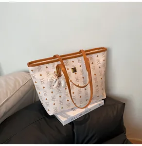Detail der weißen Leder-Shopper mit Bären-Print und goldenem Metall-Logo-Schild