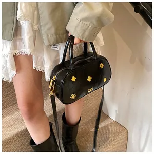 Detail of vintage black Boston bag with gold floral rivets and glossy leather texture