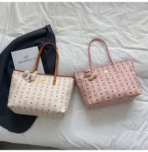 Detail von Vintage-Tote-Bags mit Bären-Print und passenden Leder-Anhängern