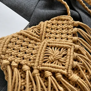 Detailed macro view of woven macrame texture and fringe tassels on a straw bag