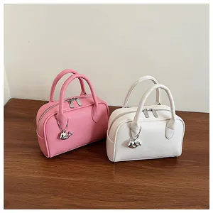 Detail of pink and white pebbled leather bowling bags with cute metal whale pendants