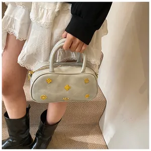 Model holding a vintage light blue Boston bag featuring gold floral metal accents and logo