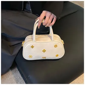 Detail of retro Boston bag showing cream leather texture and gold hardware accents