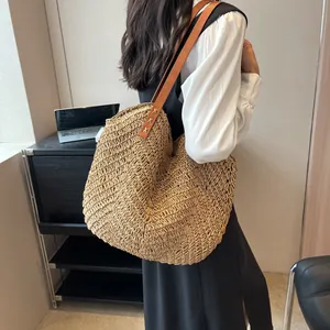 Grand sac cabas rétro en paille tressée avec bandoulière en cuir porté par un mannequin