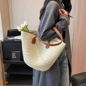 Minimalist straw tote bag with brown leather handles and interior flower decoration