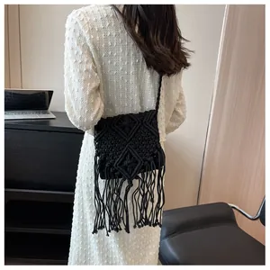 Dettaglio borsa nera in macramè con lunghe frange e trama intrecciata a rombi