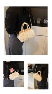 Detail of cream Boston bag with golden flower studs and detachable shoulder strap