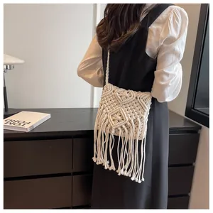 Dettaglio di borsa a tracolla boho in macramè avorio con trama intrecciata e frange