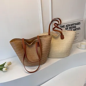 Large straw tote bag in brown and beige with leather handles for beach vacation and casual use