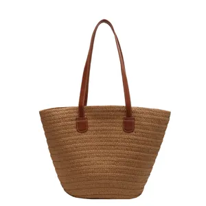 Large woven straw tote bag with brown faux leather handles for beach and summer travel