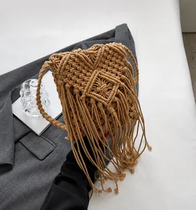 Macro shot of khaki macramé weave texture and long tassels on woven crossbody bag