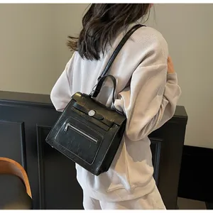 Detailed back view of a black retro crossbody bag with metallic round buckle ornaments
