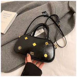Detail of black oil wax leather Boston bag with gold ornaments on a cashmere coat