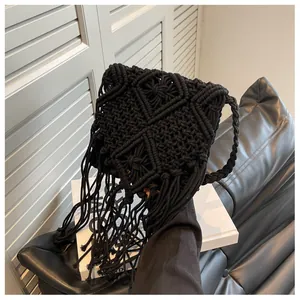Dettaglio borsa a tracolla in macramè nero fatta a mano con trama geometrica e frange
