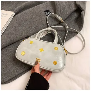 Close-up of light grey Boston bag with golden metal charms and brand logo on wool coat