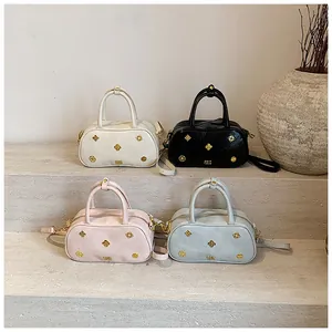 Macro shot of four Boston bags featuring golden flower rivets and textured leather finish