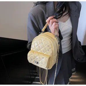Close-up of quilted lemon yellow mini backpack with sparkling crystal embellishments